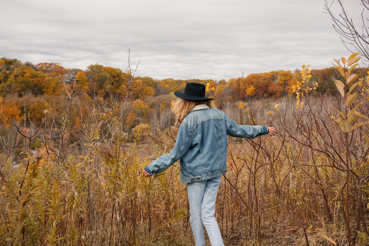 woman wearing jean jacket in meadow