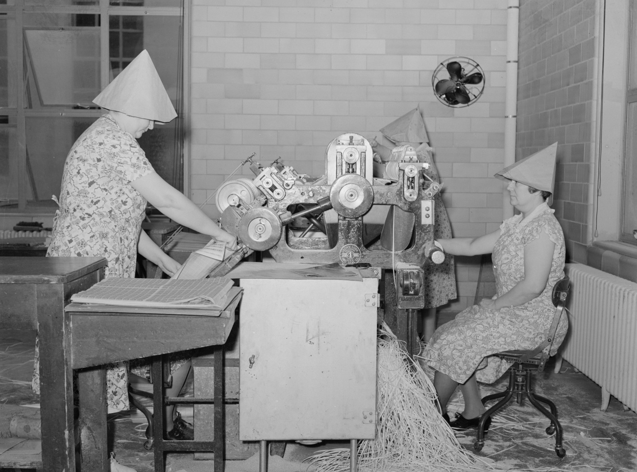 women wearing paper visors to be able to perforate postal stamps
