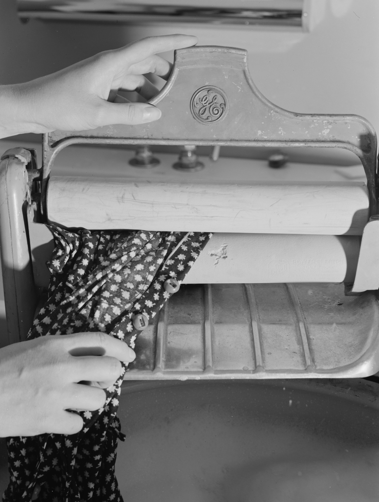 Woman Using a Wringer to Dry Clothing