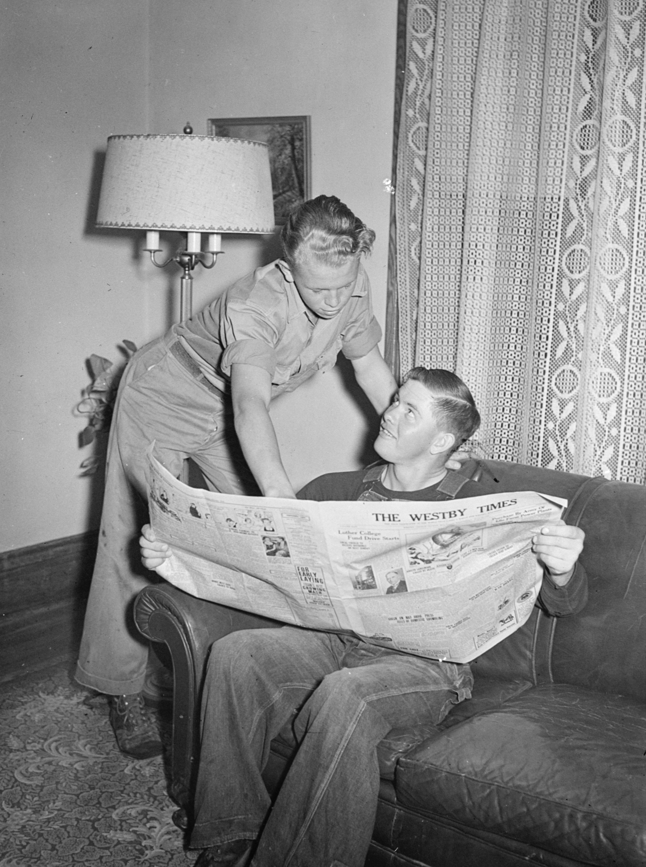Two Young Men Reading a Newspaper