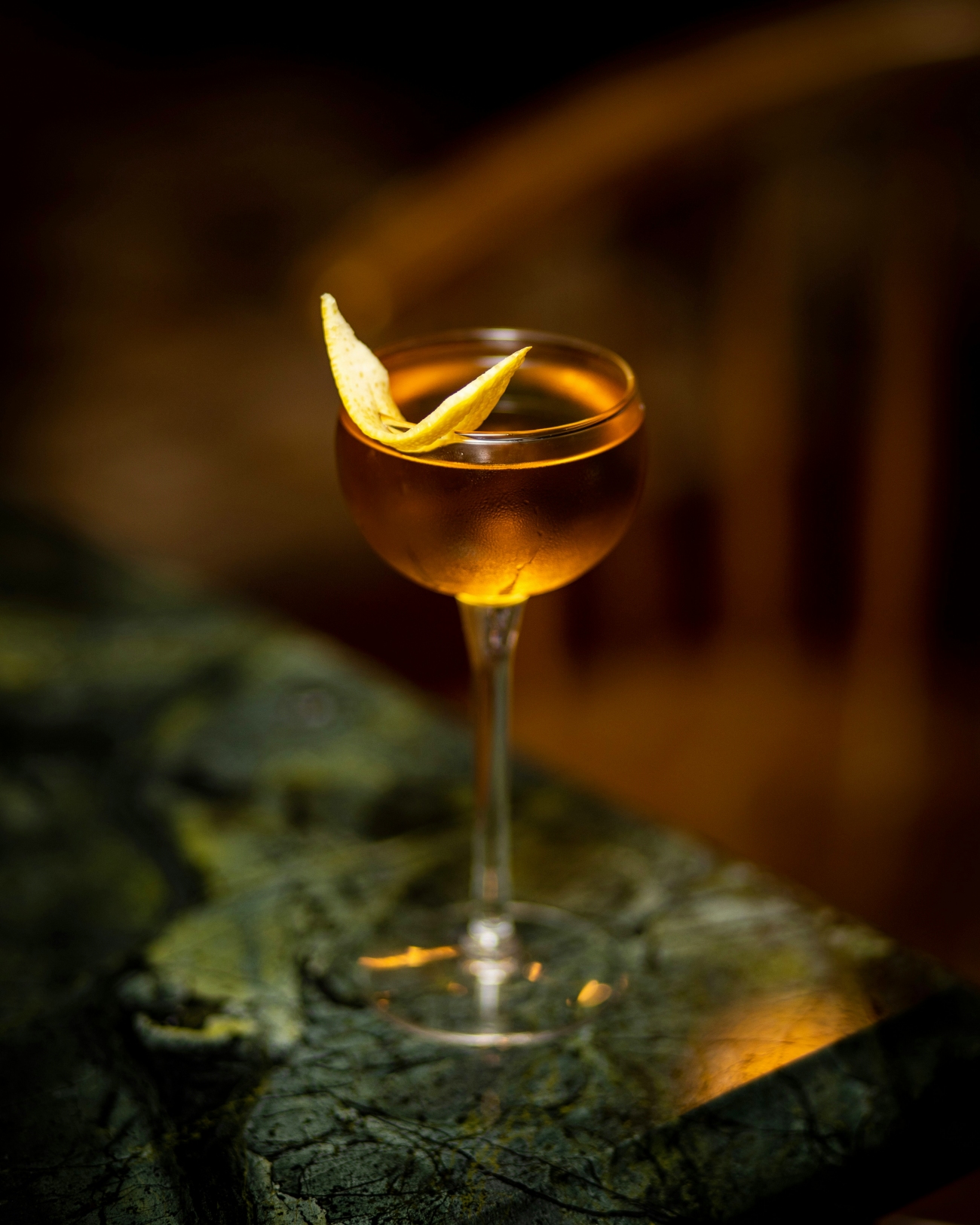 Amber Colored Cocktail with Lemon Zest