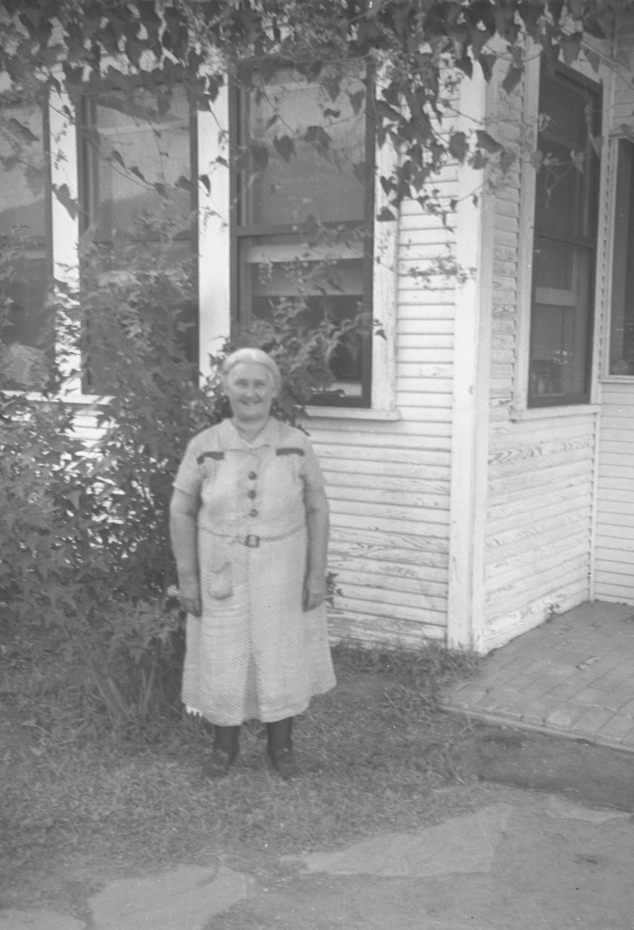 Older Woman Standing Outside a House