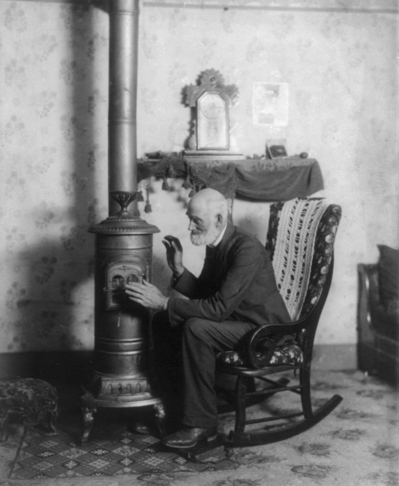 Older Man Using Small Stove for Warmth