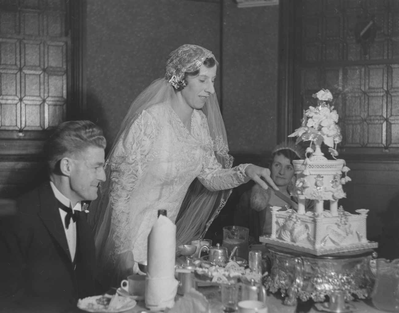 1910s Bride cutting Elaborate Wedding Cake