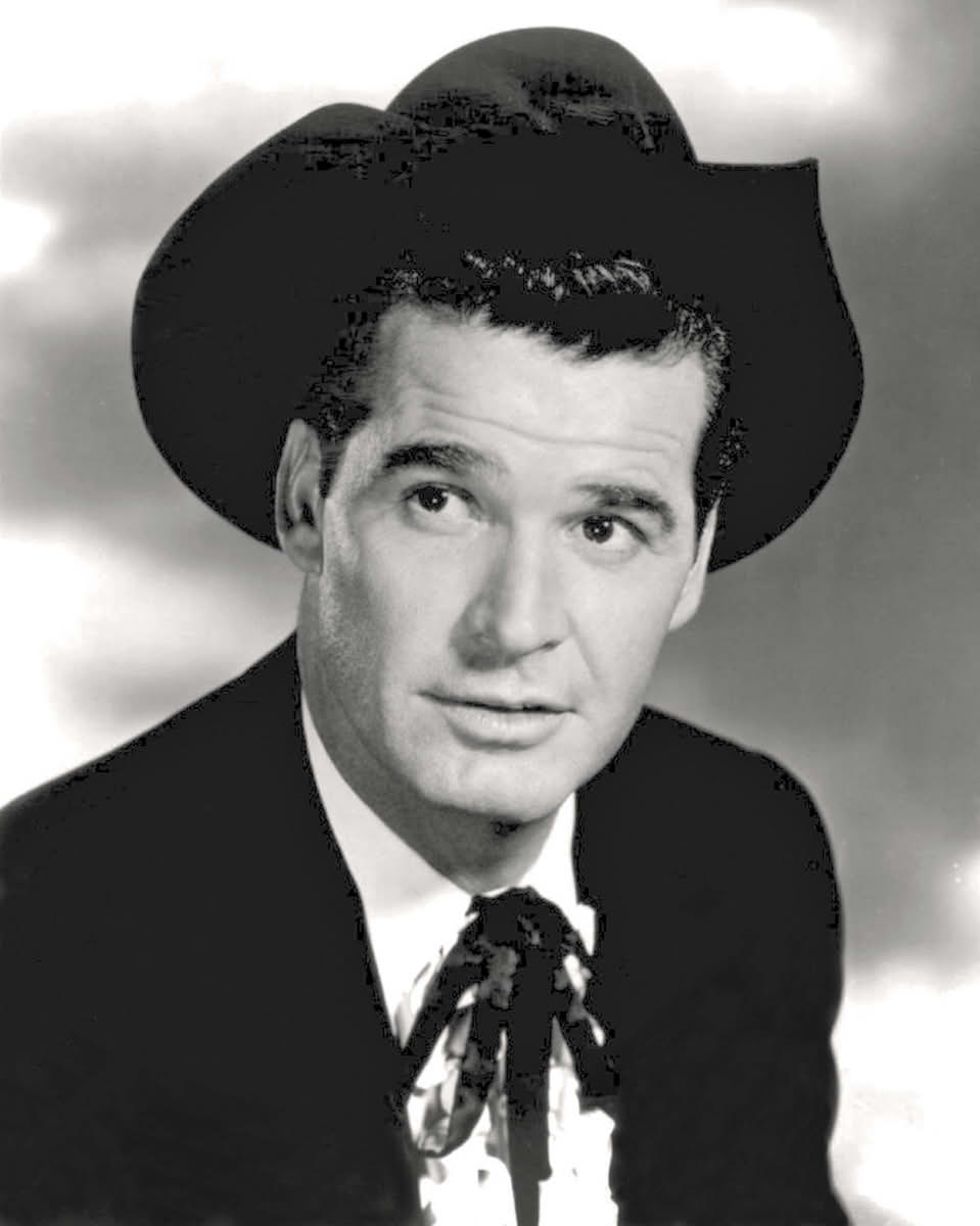 Black and white photo of James Garner in a western outfit: cowboy hat, black jacket, and black string tie.