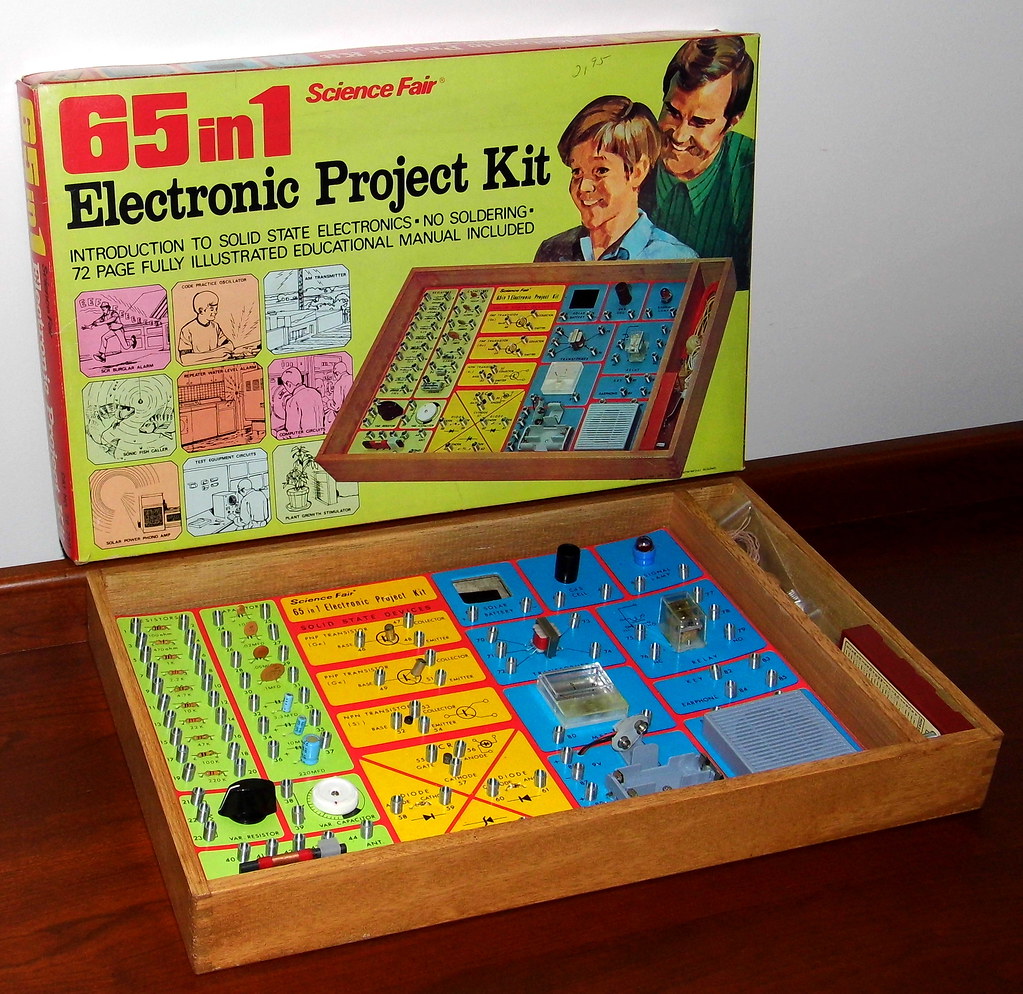 A vintage electronic project kit. The text reads: "65in1, Science Fair, Electronic Project Kit, INTRODUCTION TO SOLID STATE ELECTRONICS, NO SOLDERING, 72 PAGE FULLY ILLUSTRATED EDUCATIONAL MANUAL INCLUDED." The box is a lime green color.