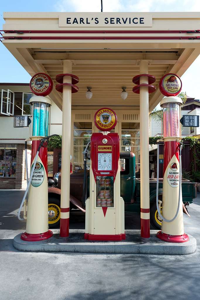 A vintage red and cream gas station with two pumps outside of two columns. The station text reads: EARL'S SERVICE