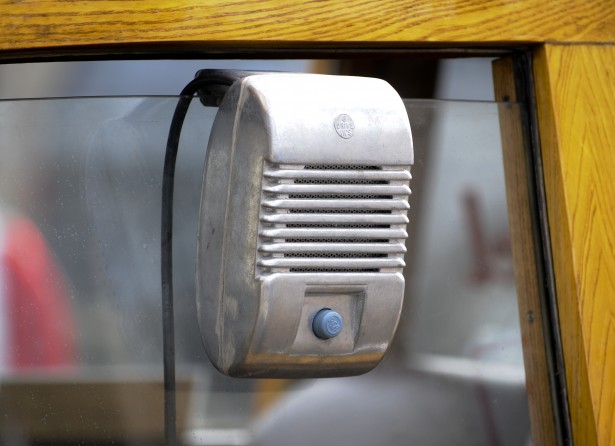Silver vintage speaker attached to a window.