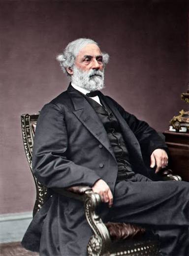 An older Robert E. Lee sits in a regal chair and wears a black suit with a bow tie. The wall behind him is a purple/brown colored wall.