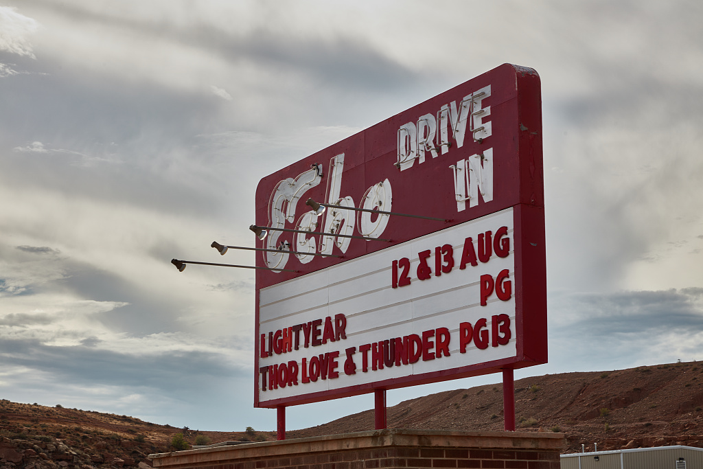 A bold red and white sign displaying upcoming showtimes for the Echo Drive-in Theater, capturing attention with its vibrant colors.